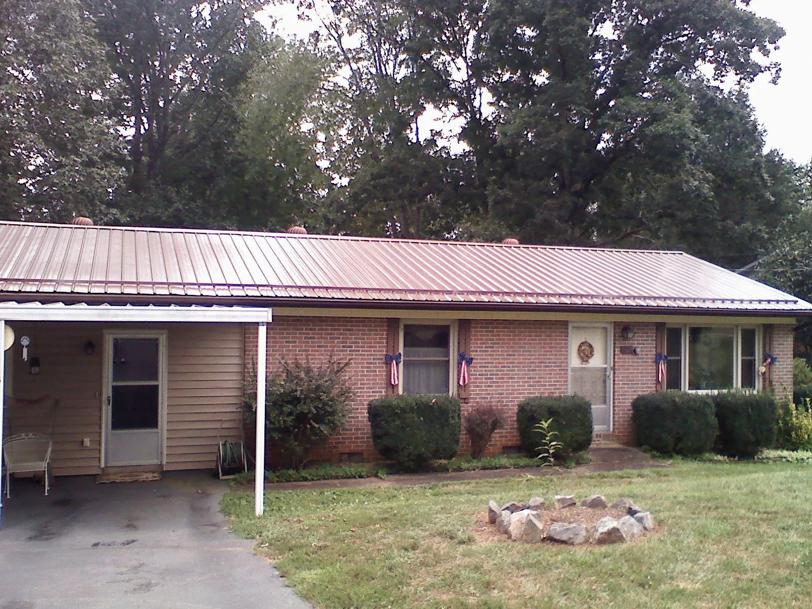 Bronze metal roof and carport on a brick ranch home — Roof Repair work by our crew in Haverhill